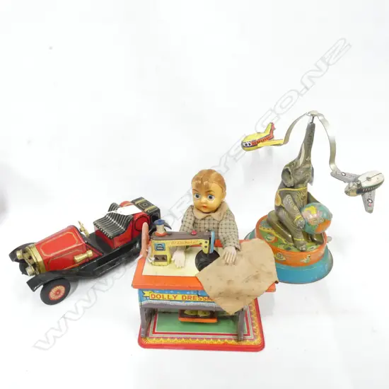 THRE TIN PLATE TOYS; 1 BATTERY OPERATED DOLLY DRESSMAKER  /CRAGTON 1914 RED CAR & CIRCUS ELEPHANT BALANCING 2 PLANES